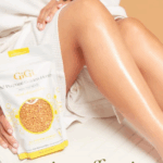 Gambe lisce e idratate accanto a una confezione di cera GiGi All Purpose Golden Honey, tenuta in mano da una donna in accappatoio.