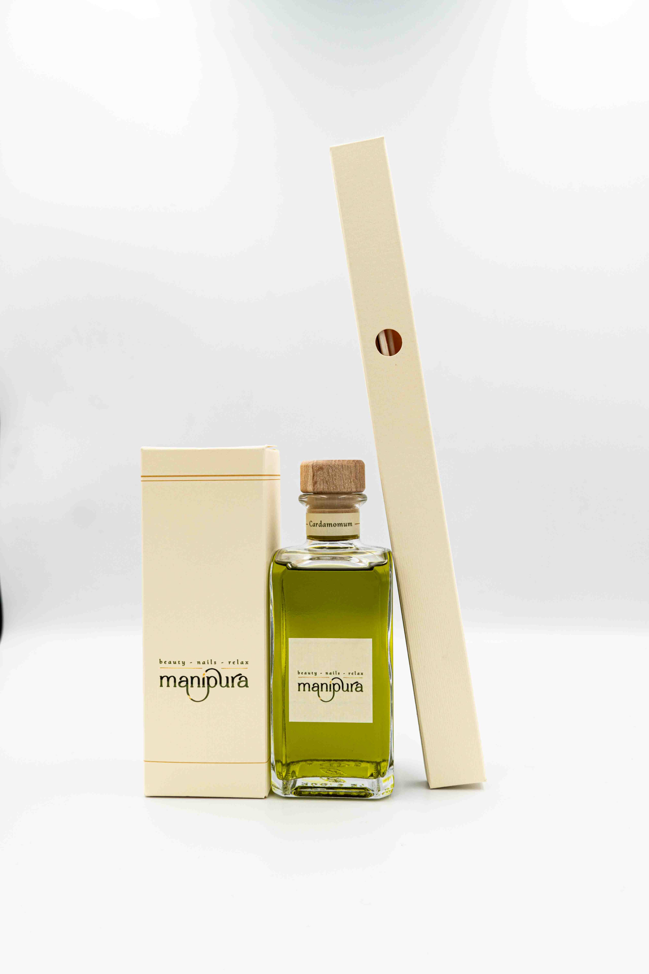 Boccetta in vetro del profumatore ambiente Manipura alla fragranza Cardamomum, su sfondo bianco.