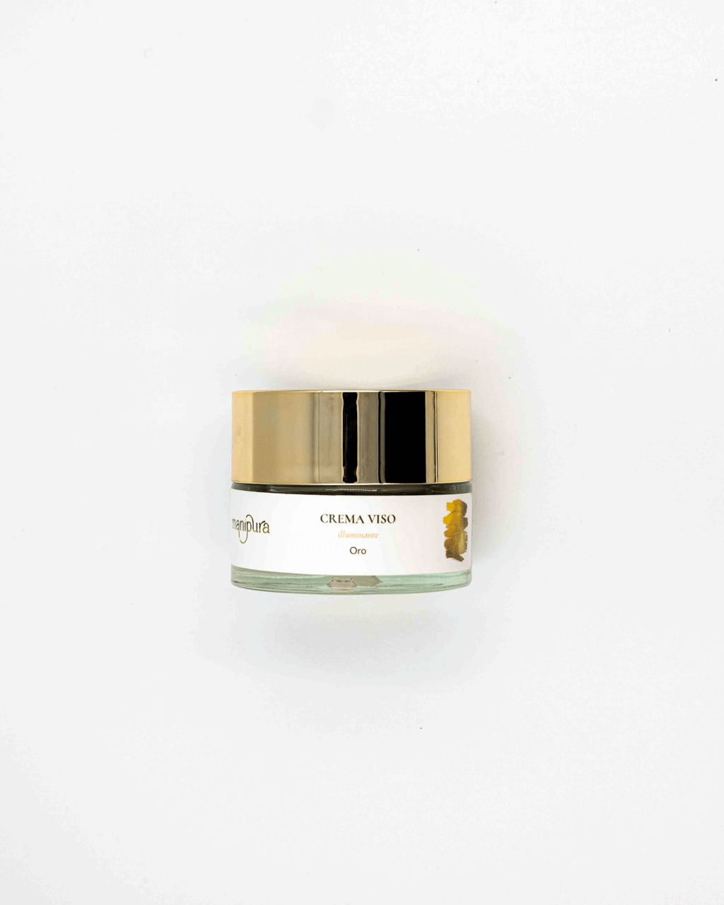Vasetto di Crema Viso Illuminante Oro Manipura con tappo dorato, fotografato dall’alto su sfondo bianco.