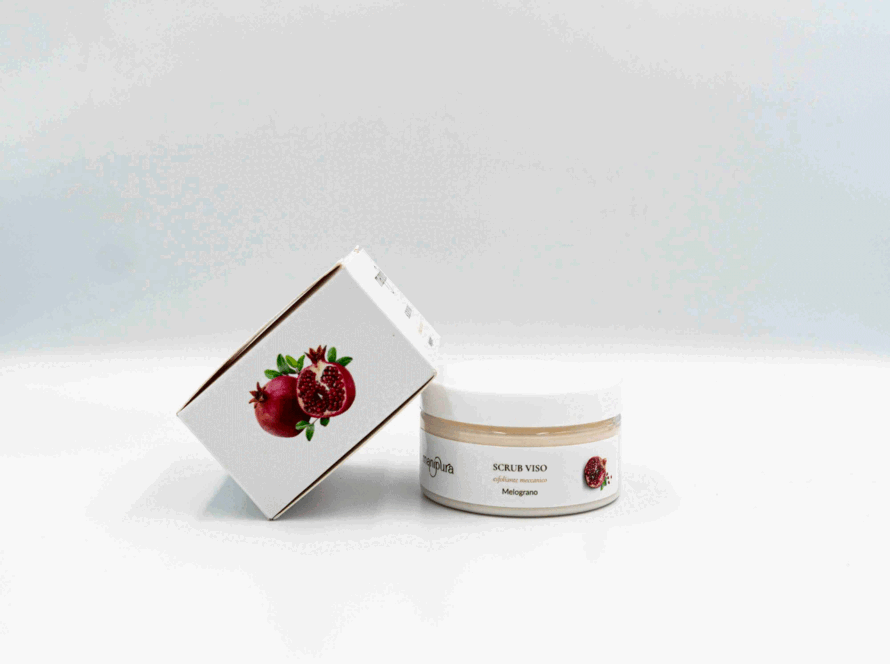 Scrub viso Manipura al melograno con vasetto aperto e confezione esterna illustrata, posizionati su sfondo bianco.